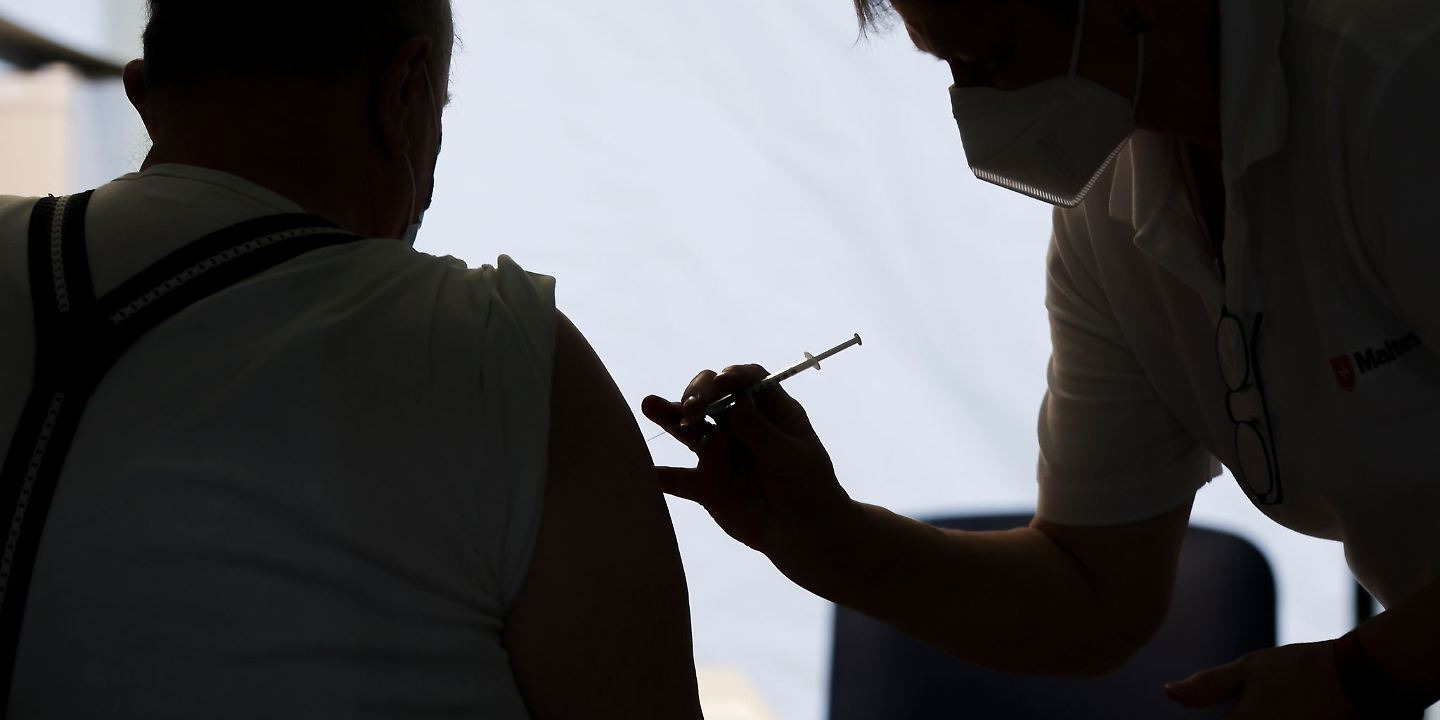 Eine Mitarbeiterin der Malteser impft einen Bürger in einem Impfzentrum in Sachsen-Anhalt.  Experten halten die vom designierten Bundeskanzler Olaf Scholz (SPD) angepeilten 30 Millionen zusätzlichen Impfungen bis Weihnachten für sehr ehrgeizig.