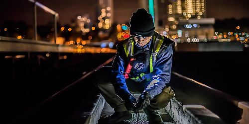 Arbeiter am Gleis arbeitet bei Nacht