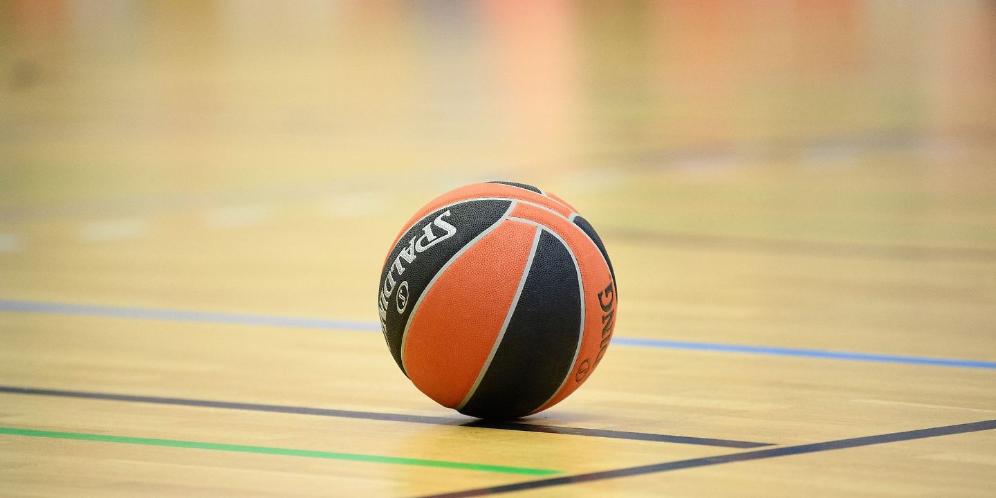 Ein Ball liegt auf einem Basketball-Spielfeld.